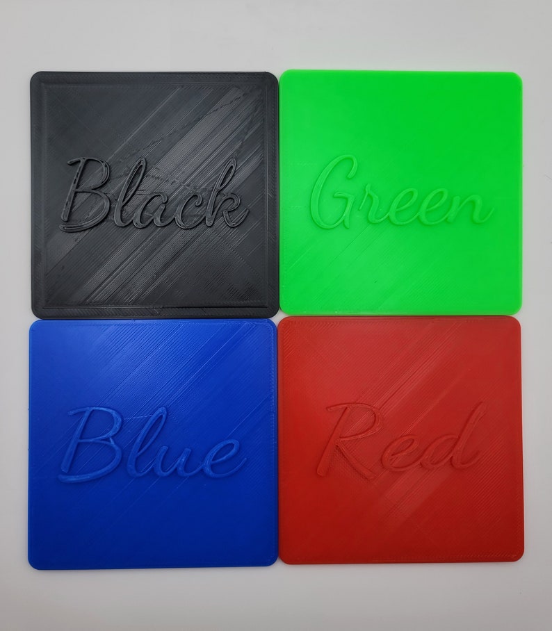 Puede incluir: Cuatro posavasos cuadrados en negro, verde, azul y rojo. Cada posavasos presenta una inscripci&oacute;n en relieve en letra cursiva en el centro que coincide con su color base. El negro dice Black, el verde Green, el azul Blue y el rojo Red.