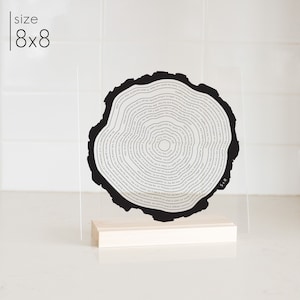 This is a tree ring acrylic stand art. It is printed in black and in a wood stand. It is personalized to your story.