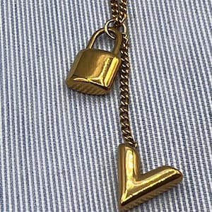 Gold Tone V and padlock pendants on a 21 inch long chain.  - Free Shipping
