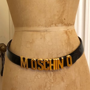 Vintage Black Leather and Gold Tone Floating Letters Moschino Belt by Redwall Italia. Size 44 (read description). Excellent condition.