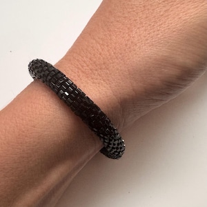 May include: A black beaded bracelet with a stretchy design.