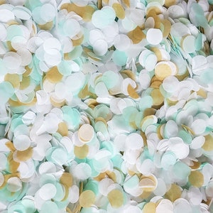 Peut inclure: Un m&eacute;lange de confettis blancs, bleu clair et dor&eacute;s. Les confettis sont en papier et ont la forme de cercles.