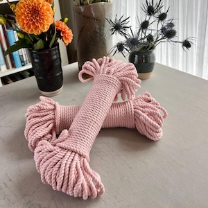 May include: Two spools of pink cotton rope, each wound into a neat coil. The rope is soft and textured, perfect for crafting projects.