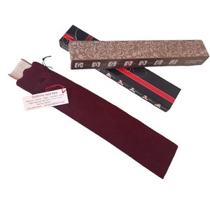 May include: A burgundy velvet fan case with a white label that reads "DeAnita Hand Fans" and includes the company's website address. The case is lying on top of a brown and black box with a floral design and the company's logo.