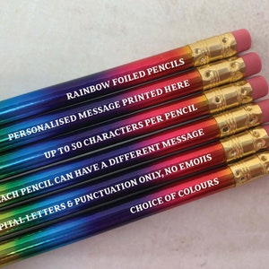 May include: A set of rainbow foiled pencils with a personalized message printed on each one. The message reads "RAINBOW FOILED PENCILS", "PERSONALISED MESSAGE PRINTED HERE", "UP TO 50 CHARACTERS PER PENCIL", "EACH PENCIL CAN HAVE A DIFFERENT MESSAGE", "CAPITAL LETTERS & PUNCTUATION ONLY, NO EMOJIS", and "CHOICE OF COLOURS".