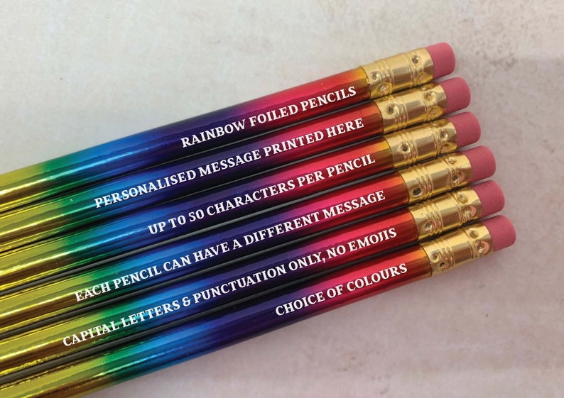 May include: A set of rainbow foiled pencils with a personalized message printed on each one. The message reads "RAINBOW FOILED PENCILS", "PERSONALISED MESSAGE PRINTED HERE", "UP TO 50 CHARACTERS PER PENCIL", "EACH PENCIL CAN HAVE A DIFFERENT MESSAGE", "CAPITAL LETTERS & PUNCTUATION ONLY, NO EMOJIS", and "CHOICE OF COLOURS".