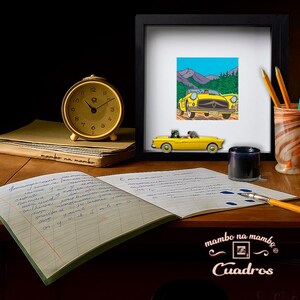 Puede incluir: Una impresi&oacute;n enmarcada de un coche amarillo vintage con un fondo de monta&ntilde;a, junto a un coche de juguete a juego. Un reloj dorado, l&aacute;pices, un tintero y un cuaderno abierto est&aacute;n sobre un escritorio de madera. El texto "mambo na mambo Cuadros" es visible.