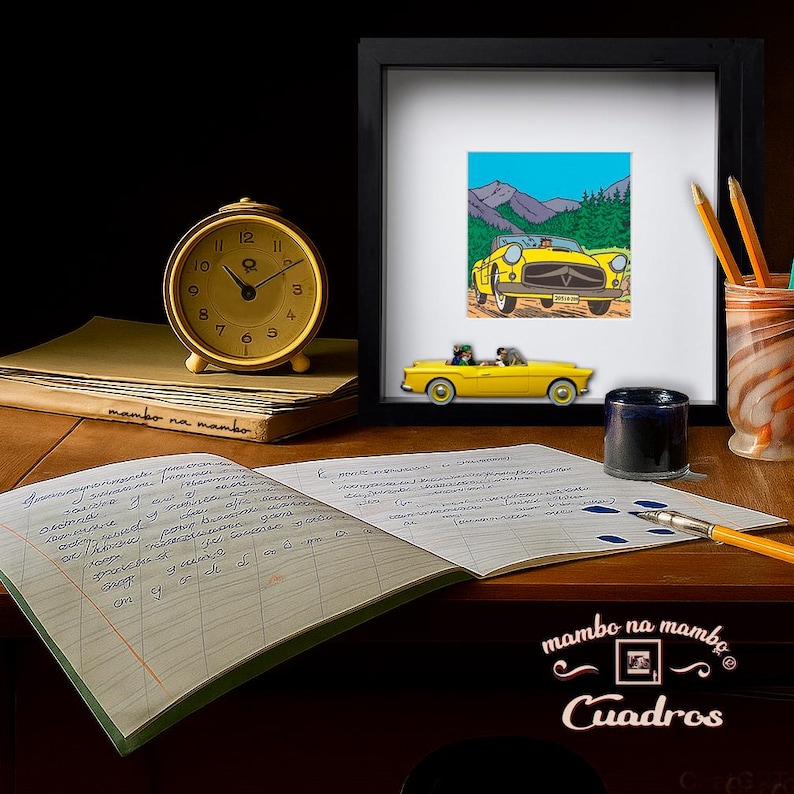 Puede incluir: Una impresi&oacute;n enmarcada de un coche amarillo vintage con un fondo de monta&ntilde;a, junto a un coche de juguete a juego. Un reloj dorado, l&aacute;pices, un tintero y un cuaderno abierto est&aacute;n sobre un escritorio de madera. El texto "mambo na mambo Cuadros" es visible.