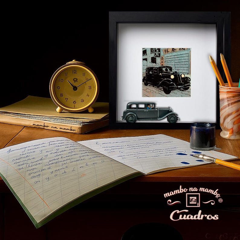 May include: A still life featuring a vintage gold alarm clock, a framed picture of a classic car, and an open notebook with handwritten text. A small car model and inkwell are also present. The scene is set on a wooden desk.
