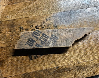 May include: A wooden state of Tennessee shaped sign with the text "OSP 430 - ON LOT 1" printed on it. The sign is sitting on a wooden surface.