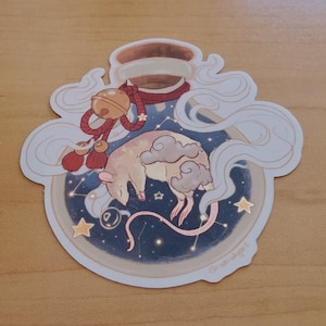 May include: A sticker featuring a sleeping rat inside a bottle with a starry night sky design. The rat is beige with cloud-like markings. The bottle has a bell and red accents. The sticker has a white border and a light brown background.