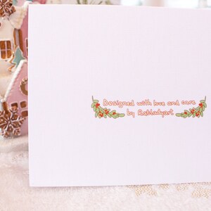 May include: A white card with a pink border and a green and red floral design. The text "Designed with love and care by Ratladyart" is printed on the card.