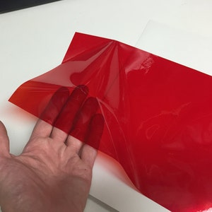 Rolls of Transparent Colored Plastic , Adhesive Coated Red