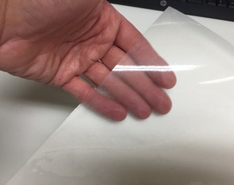 May include: A clear, transparent sheet of adhesive vinyl, often used for crafting and DIY projects.