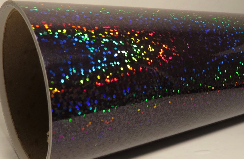 May include: A roll of black iridescent vinyl with a holographic finish. The vinyl has a subtle sparkle and is perfect for crafting and DIY projects.