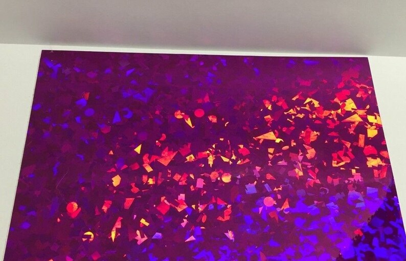 K&ouml;nnte beinhalten: Ein Bogen schillerndes Papier mit einem lebendigen, mehrfarbigen Muster. Das Design zeigt eine Mischung aus lila, roten, orangen und blauen Formen, die einen schimmernden Effekt erzeugen. Das Papier hat eine gl&auml;nzende Oberfl&auml;che, die das Licht reflektiert.