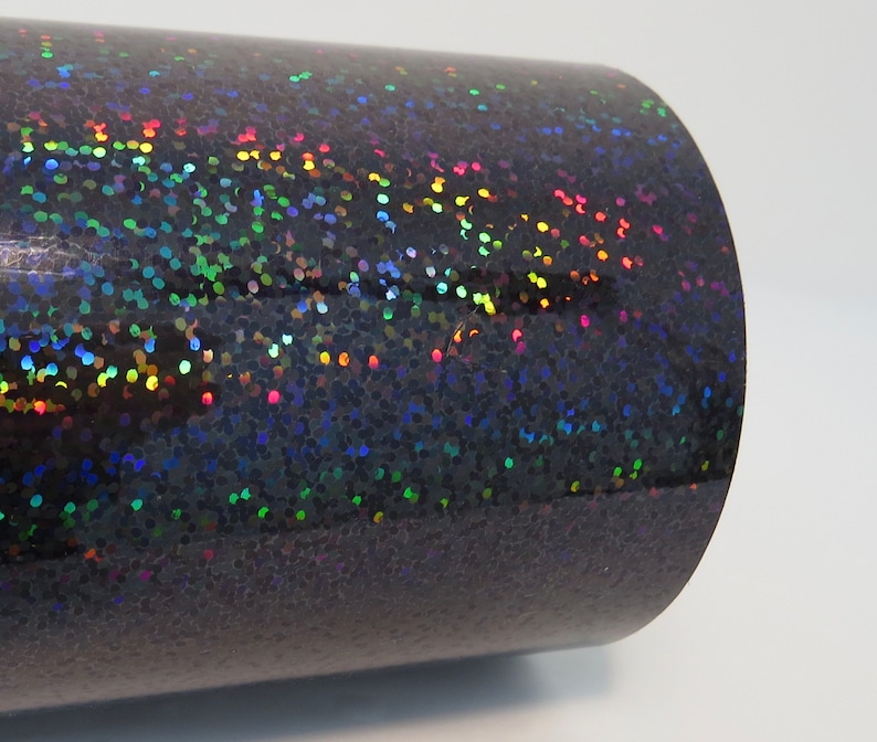 May include: A roll of black iridescent vinyl with a holographic finish. The vinyl has a subtle sparkle and is perfect for crafting projects.