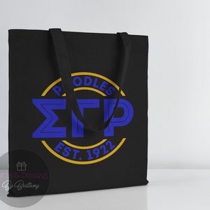 May include: Black canvas tote bag with a yellow circle and blue lettering that reads "Poodles &Sigma;TP Est. 1922".