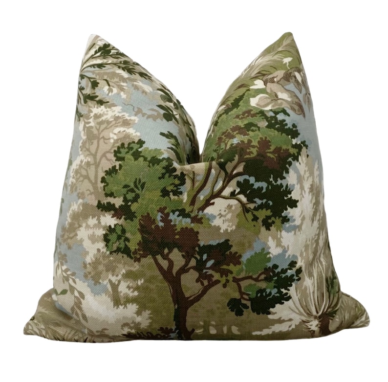 May include: A green, brown, and blue patterned throw pillow with a forest scene. The pillow is made of a soft, textured fabric.