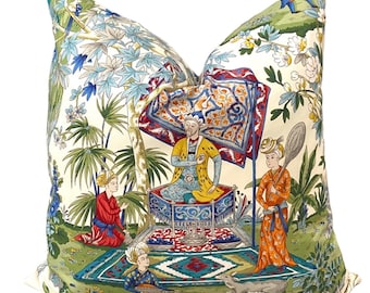 May include: A decorative pillow featuring a colorful illustration of a scene from a Persian garden. The illustration depicts a man sitting on a throne, surrounded by other figures and a lush garden.