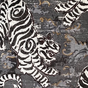 May include: A black and white patterned fabric with a repeating design of tigers. The tigers are stylized and have a traditional Japanese look. The background is a dark gray with gold accents.