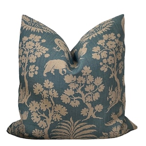 May include: A teal blue throw pillow with a beige floral and animal print. The print features trees, birds, and a rhinoceros.