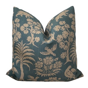 May include: A teal blue throw pillow with a beige floral and bird pattern. The pillow is made of a soft, textured fabric.