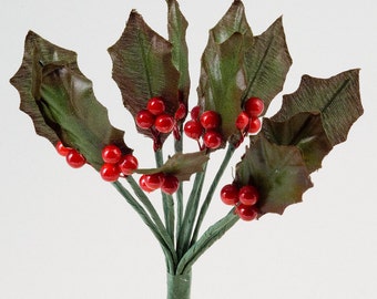May include: A bunch of artificial holly sprigs with red berries. The leaves are green and have a textured surface.