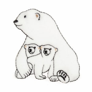 May include: A white polar bear with two cubs. The mother bear is sitting with her cubs nestled in front of her.