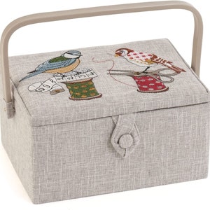 May include: A gray fabric sewing box with a beige handle. The lid features an embroidered design of two birds, one with a spool of thread and scissors, and the other with a spool of thread and a measuring tape. The box has a button closure.