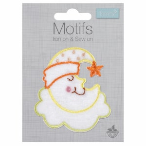 Puede incluir: Parche blanco para planchar o coser con un diseño bordado de una luna creciente amarilla con una cara dormida, que lleva un gorro rojo y naranja y una pequeña estrella naranja. El texto "Motifs Iron on & Sew on" está impreso en la tarjeta.
