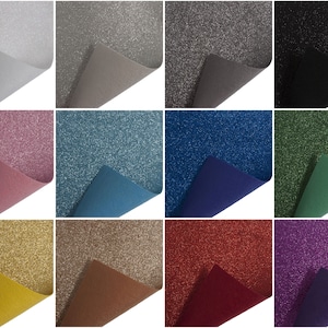 Peut inclure: Douze échantillons de tissu pailleté de différentes couleurs, dont le blanc, le gris, le rose, le bleu, le vert, l'or, le marron, le rouge et le violet. Chaque échantillon est plié pour montrer l'envers du tissu.