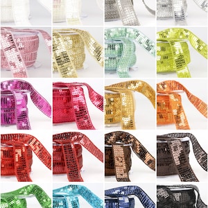 May include: Assortment of 12 rolls of sequined trim in various colours, including silver, gold, pink, green, blue, red, and brown. Each roll is approximately 1 yard long and 1 inch wide.