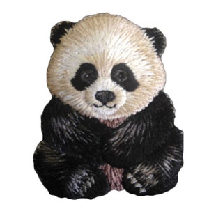 Pode incluir: Um remendo bordado com um urso panda preto e branco. O panda está sentado com as patas à sua frente. O remendo tem um fundo branco e costuras pretas.