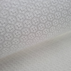 Könnte beinhalten: Weißes Papier mit einem sich wiederholenden Muster aus grauen sechseckigen Formen mit einem kleinen Blumendesign in jedem Sechseck.