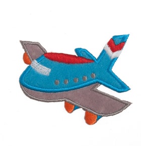 May include: A blue aeroplane with red and white accents. The aeroplane has a grey wing and a red stripe on the tail.