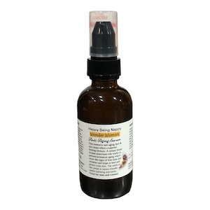 May include: A brown glass bottle with a black pump top dispenser. The bottle is labeled "Happy Being Nappy Wonder Woman Anti-Aging Serum". The label also includes a description of the product's benefits and a statement that it is "Great for men and women!"