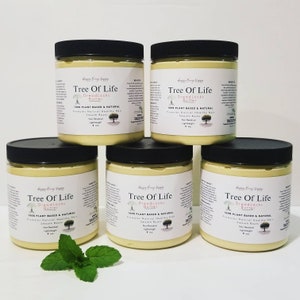 May include: Five jars of Tree of Life Dreadlocks Butter, each with a black lid and a white label. The label includes text and a tree graphic. The jars are filled with a light yellow butter. A sprig of mint is in front.