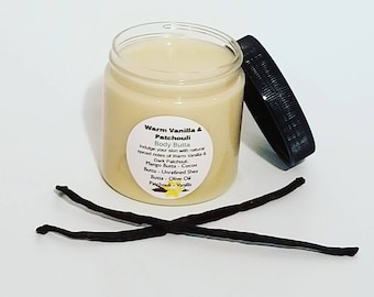 May include: A glass jar of warm vanilla and patchouli body butter. The jar has a black lid and a white label with the text "Warm Vanilla & Patchouli Body Butta" and a list of ingredients. Two vanilla beans are in the foreground.