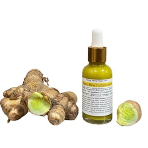 Puede incluir: Una botella de vidrio de jugo de cúrcuma cruda orgánica con tapa dorada y gotero. La botella está etiquetada con "Happy Being Nappy.com" y "Jugo de cúrcuma cruda orgánica". La botella está junto a un grupo de raíz de cúrcuma.