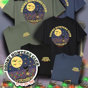 May include: Five different t-shirts with a green, black, blue, and two shades of gray. Each shirt features a circular graphic of a person shooting at drones with the text "Drone Hunters Club" and "Off the Grid John".