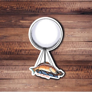 May include: A white balloon with a fish and the text "Off the Grid John" hanging from it. The balloon is against a wood background.