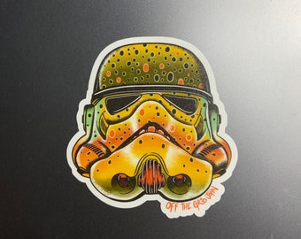 May include: A yellow and green sticker of a Star Wars Stormtrooper helmet with a trout pattern. The sticker has the text "OFF THE GRID JOHN" at the bottom.