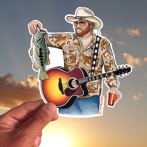 May include: A cartoon illustration of a man wearing a cowboy hat, camouflage shirt, and jeans. He is holding a guitar and a fish. The text "OFF THE GRID MAN" is on the bottom of the image.