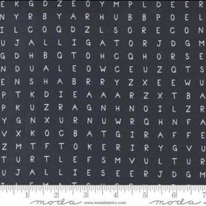 May include: Black fabric with a white alphabet pattern. The letters are randomly arranged and repeated throughout the fabric. The fabric has a white ruler with the word "moda" printed on it.