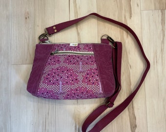 Berry cross-body bag with waxed canvas accents and adjustable strap.