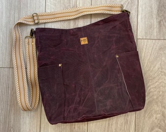 Large waxed canvas tote in burgundy with an adjustable cotton webbing strap. Compass pattern from Noodle Head Patterns.