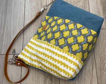 Handmade canvas tote, with a blue, yellow, and white design and leather shoulder strap with silver hardware.