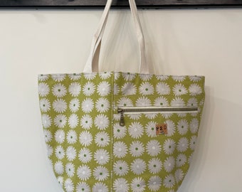 Canvas Cresent Tote in light green daisy with two zip pockets and roomy interior.