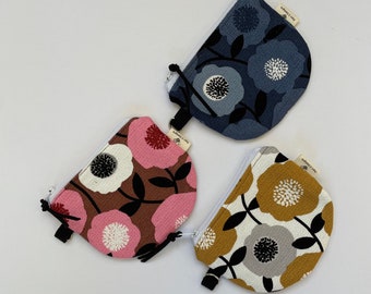 Coin purses from the Retro Bloom Collection. One in each color (pink, gold, blue) with rounded bottoms and attached key ring.